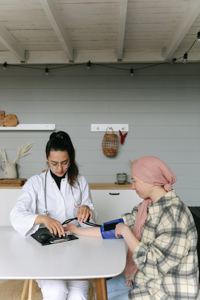 A doctor measures a woman's blood pressure in a home setting. Health care and support.
